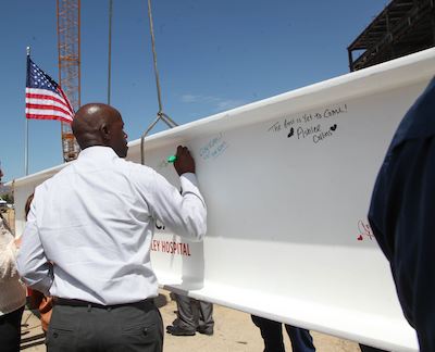 Personas firmando la viga de acero de la nueva torre de pacientes