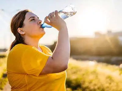 A woman drinking from a water bottle